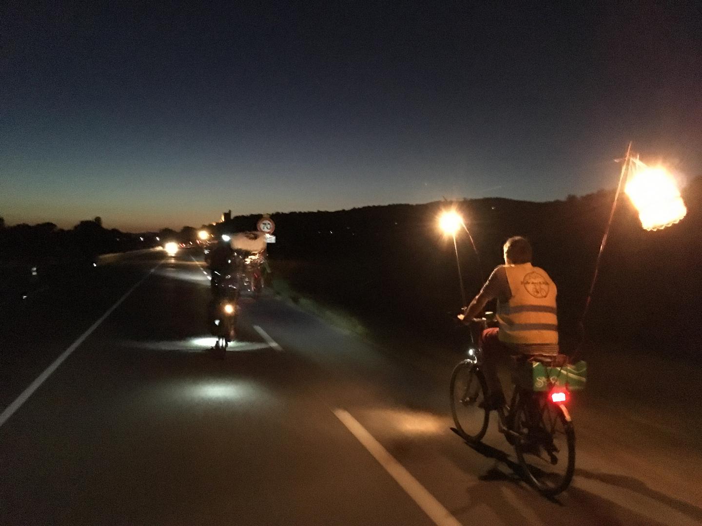 Des cyclistes de nuit, éclairés par des lanternes
